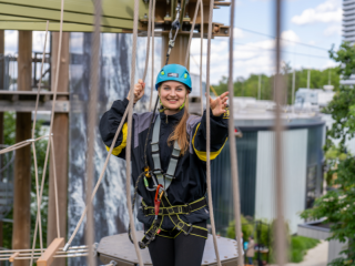 Eine Frau im Hochseilklettergarten der Jochen Schweizer Arena