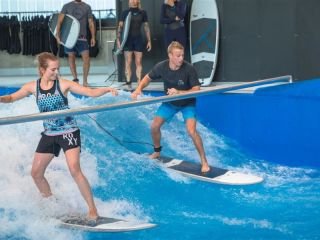 zwei Menschen surfen auf der Indoor Welle in der Jochen Schweizer Arena