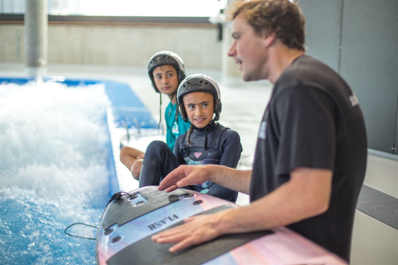 Bild - ein Instruktor und 2 Kinder sitzen an der stehenden Welle