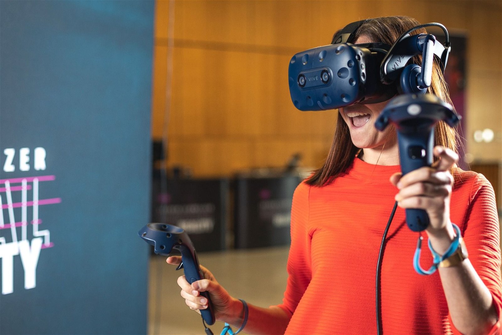 Bild - eine Frau mit einer VR Brille und 2 Controllern in der Hand