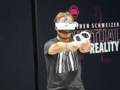 Ein Mann mit einer VR Brille und 2 Controllern spielt ein VR Spiel