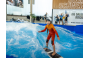 ThumbnailEin Mädchen, wie sie beim Indoor Surfen Kindergeburtstag auf der stehenden Welle in der Jochen Schweizer Arena surft