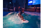 ThumbnailEin Mann surft auf der stehenden Welle in der Jochen Schweizer Arena während der Pure Surf Night
