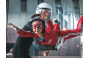 ThumbnailIndoor Skydiving für Kinder in der Jochen Schweizer Arena: Ein Kind im roten Fluganzug schwebt im Windtunnel, professionell betreut von einem erfahrenen Instruktor.