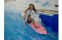 ThumbnailEine Frau surft auf einem pinken Surfbrett auf der stehenden Welle in der Jochen Schweizer Arena