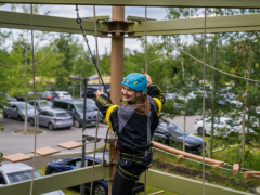 Eine glückliche Frau im Hochseilklettergarten in der Jochen Schweizer Arena