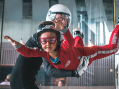 Ein Kind und ein Instruktor beim Indoor Skydiving