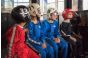 ThumbnailBodyflying für Kinder in der Jochen Schweizer Arena: Eine Gruppe junger Teilnehmer in farbigen Fluganzügen sitzt gespannt mit Helmen und Schutzbrillen vor dem Windtunnel.