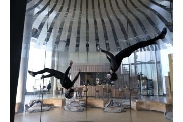 2 Menschen, die im Windkanal der Jochen Schweizer Arena kopfüber fliegen
