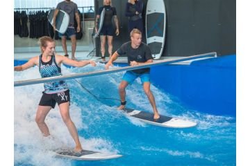 zwei Menschen surfen auf der Indoor Welle in der Jochen Schweizer Arena