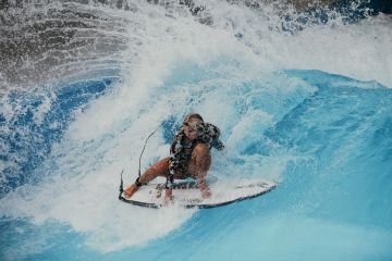eine Frau, die auf der stehenden Welle surft