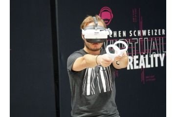 Ein Mann mit einer VR Brille und 2 Controllern spielt ein VR Spiel